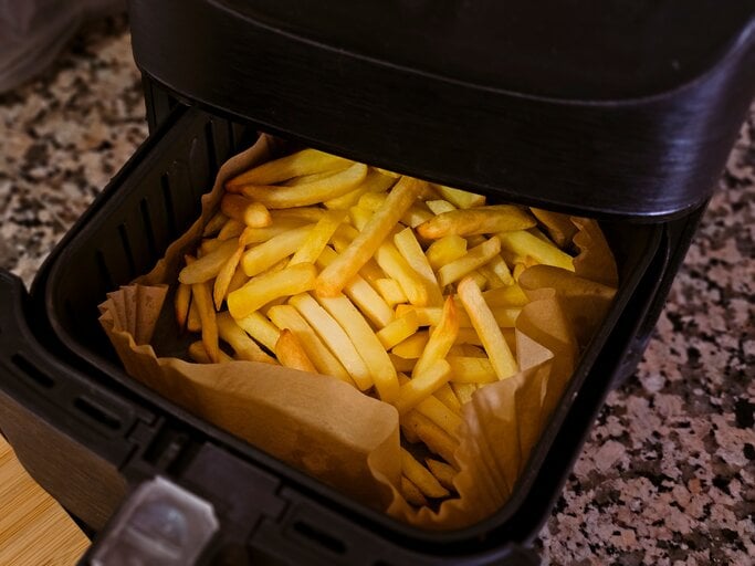 Eine Heißluftfritteuse mit Pommes.  | © AdobeStock/Elena Uve