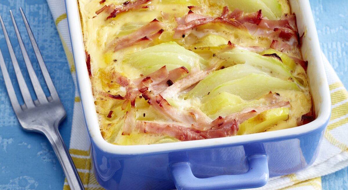 Ofen-Kohlrabi mit Schinken in eckiger Form / Küchentuch / Gabel / Draufsicht