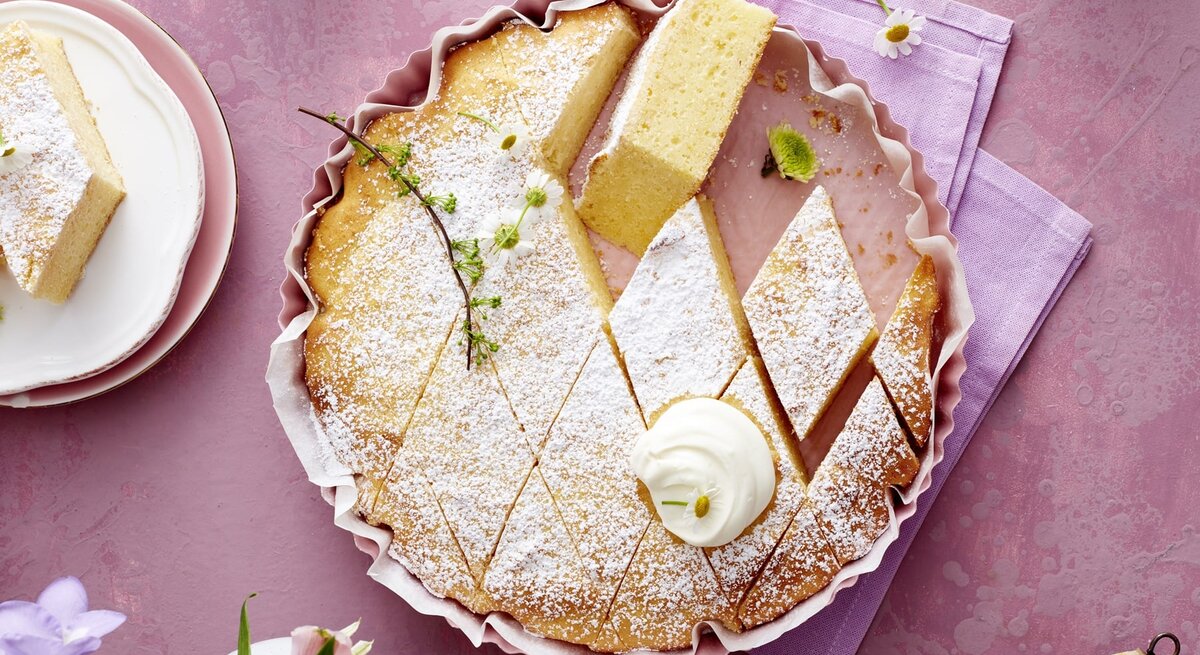 Der Kuchen in Rauten geschnitten auf einem violetten Untergrund direkt von oben fotografiert.