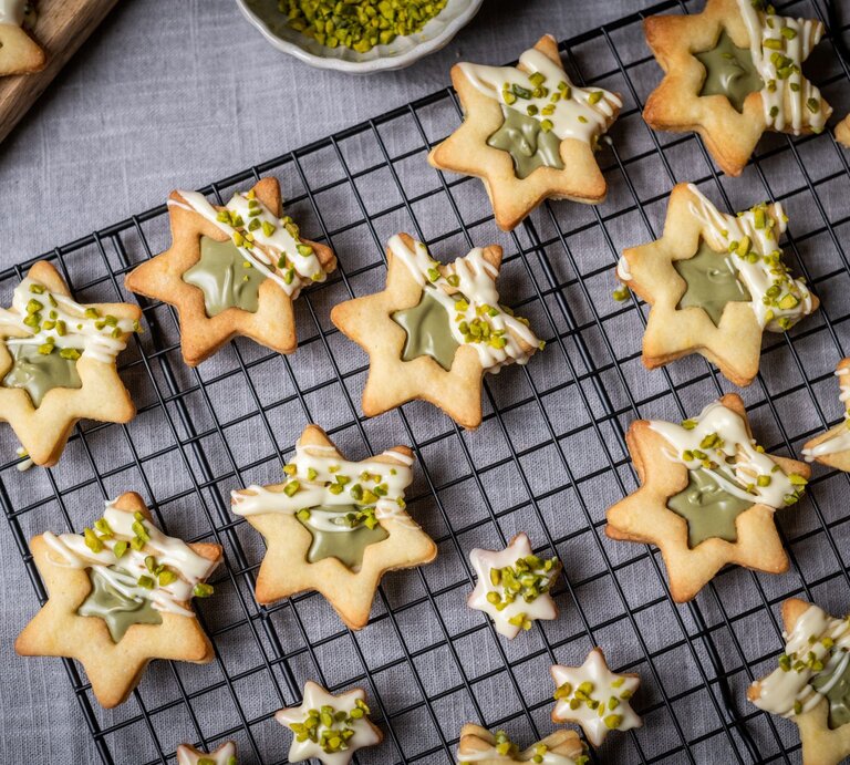 Draufsicht auf sternförmige Weihanchtsplätzchen mit Pistaziencreme.  | © AdobeStock/knipseria