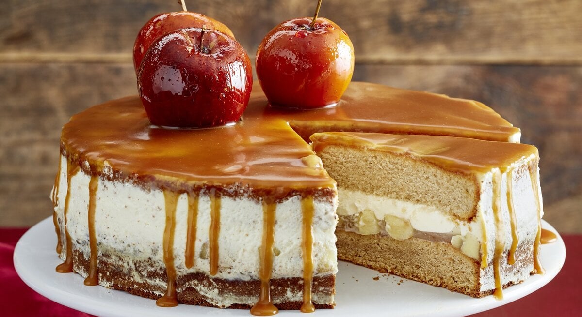 Der Kuchen auf einem Tortenständer mit weihnachtlicher Dekoration. Alles direkt von vorne fotografiert.