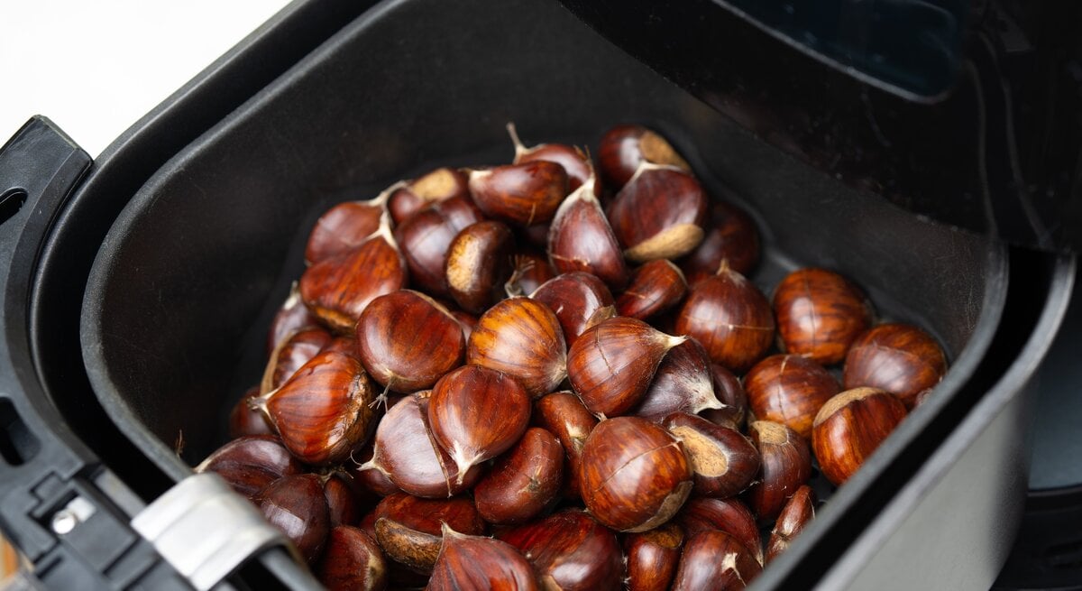 Viele Maronen in einem Korb in einem Airfryer.