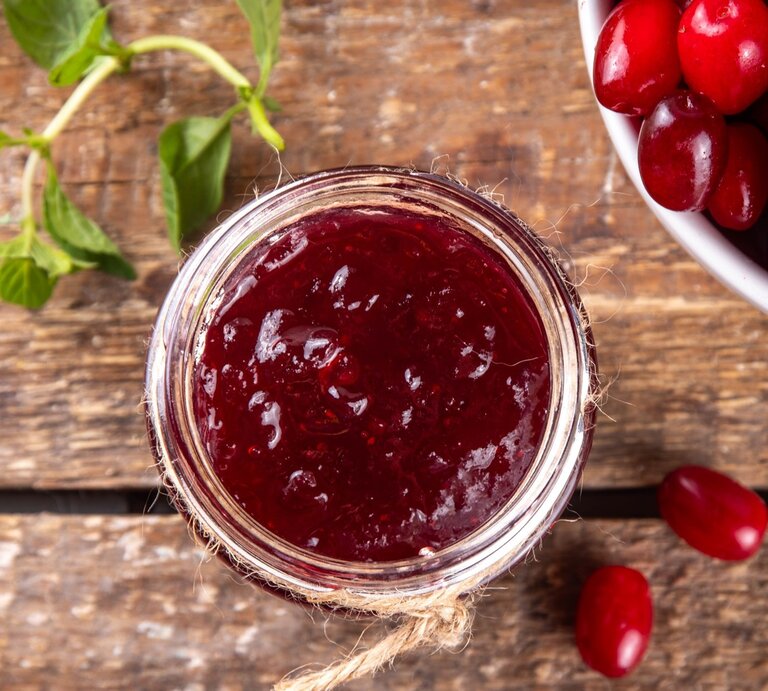 Draufsicht: Eine selbst gemachte Kornelkirschen-Marmelade / Drumherum frische Kornelkirschen / Untergrund Holz / | © Shutterstock / Rimma Bondarenko