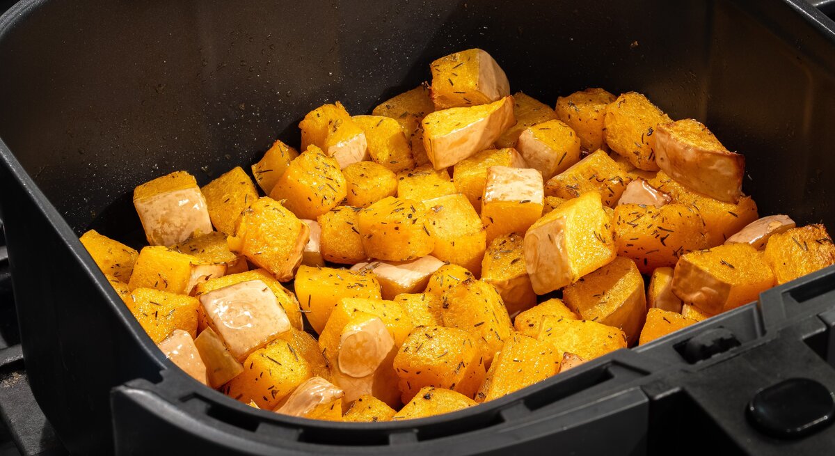 Kürbis-Würfel im Korb einer Heißluftfritteuse