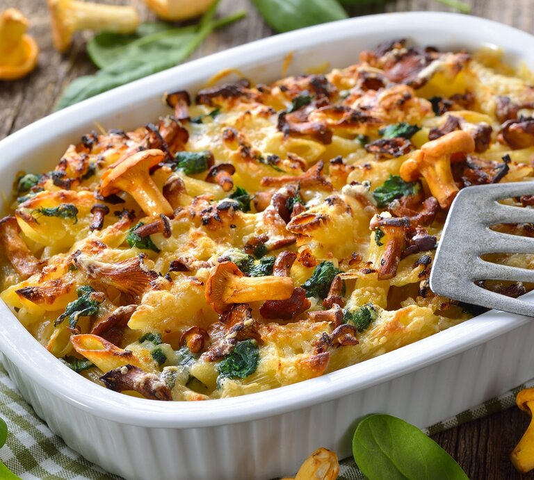 Eine Auflaufform mit dem Nudelgratin auf einem rustikalen Holztisch von schräg oben fotografiert. | © Shutterstock/ Karl Allgaeuer