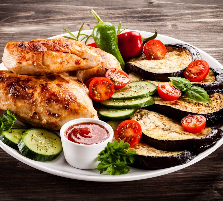 Ein Teller mit Hähnchen und gegrilltem Gemüse.  | © AdobeStock/Jacek Chabraszewski