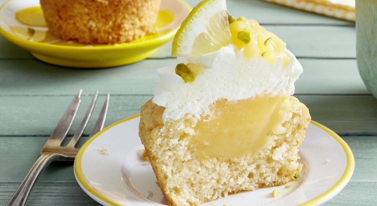 Ein Cupcake auf einem hellen Teller und hellgrünem Holztisch fotografiert