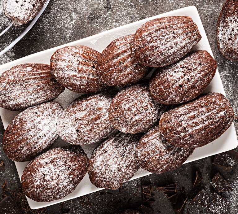 Mit Puderzucker bestäubte Bärentatzen-Plätzchen auf weißem Teller.  | © Shutterstock/Timolina