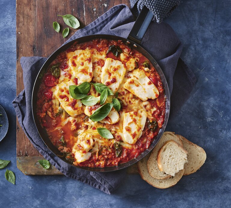 Eintopf mit Hackfleisch und Halloumi / runde Schüssel / drei Scheiben Weißbrot / frische Kräuter / Untergrund Holzbrett  | © StockFood / News Life Media 