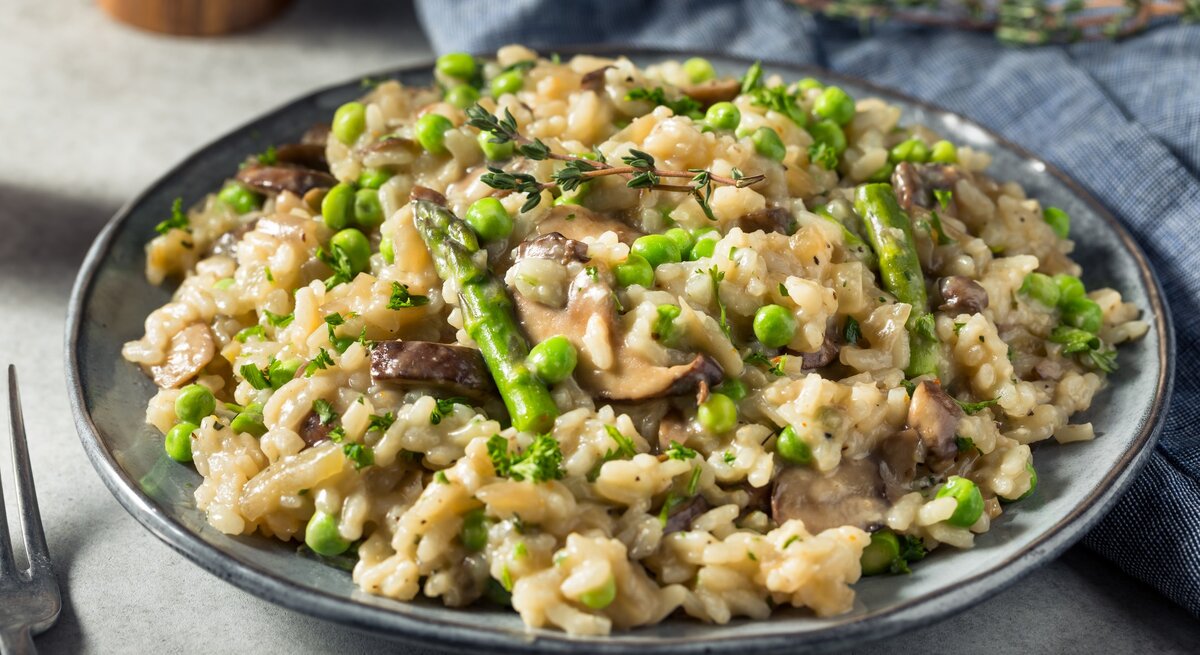 Spargel-Pilz-Risotto mit Parmesan / runder Teller / Nahaufnahme / frontal