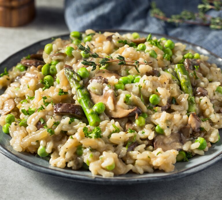 Spargel-Pilz-Risotto mit Parmesan / runder Teller / Nahaufnahme / frontal | © Getty Images / bhofack2