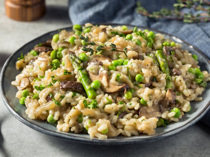 Spargel-Pilz-Risotto mit Parmesan / runder Teller / Nahaufnahme / frontal | © Getty Images / bhofack2