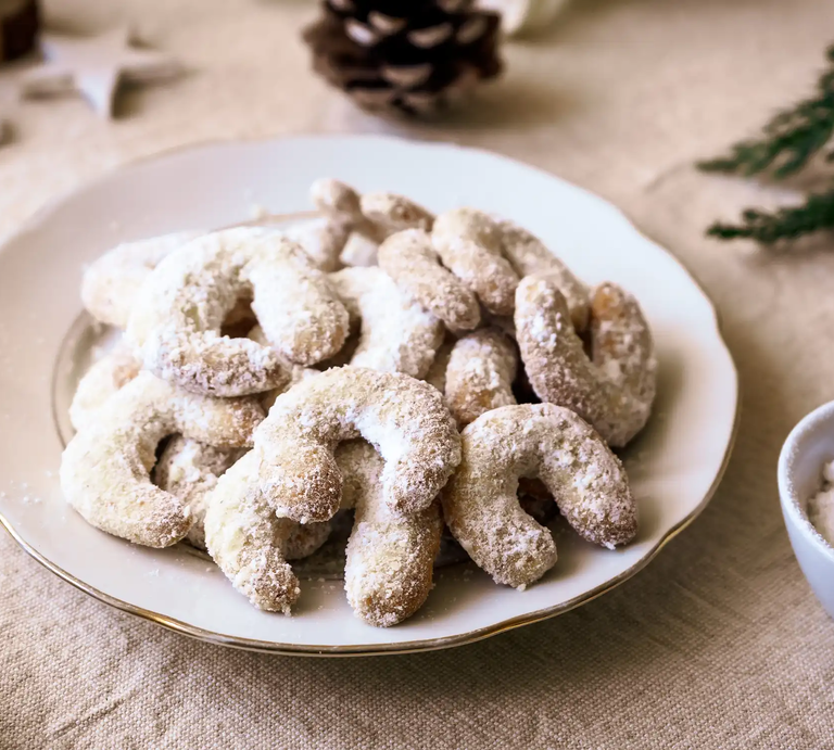 Vanillekipferl auf Teller mit weihnachtlicher Deko auf dem Tisch | © Adobe Stock/Sonja Rachbauer