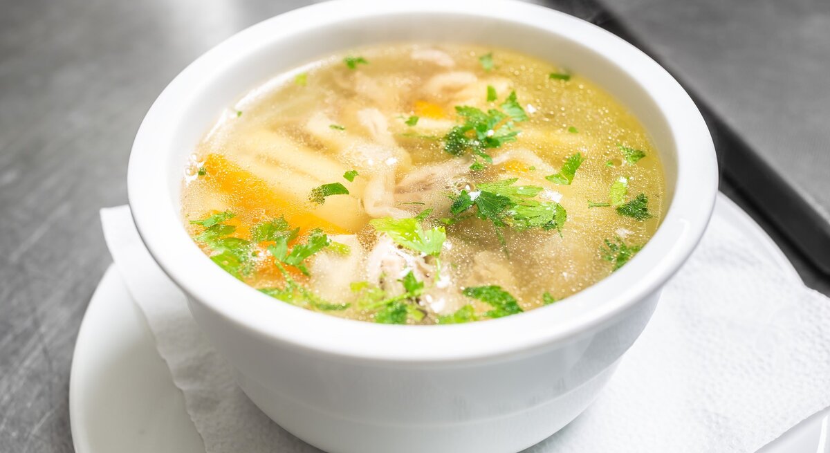 Hühnersuppe in weißer Schüssel. 