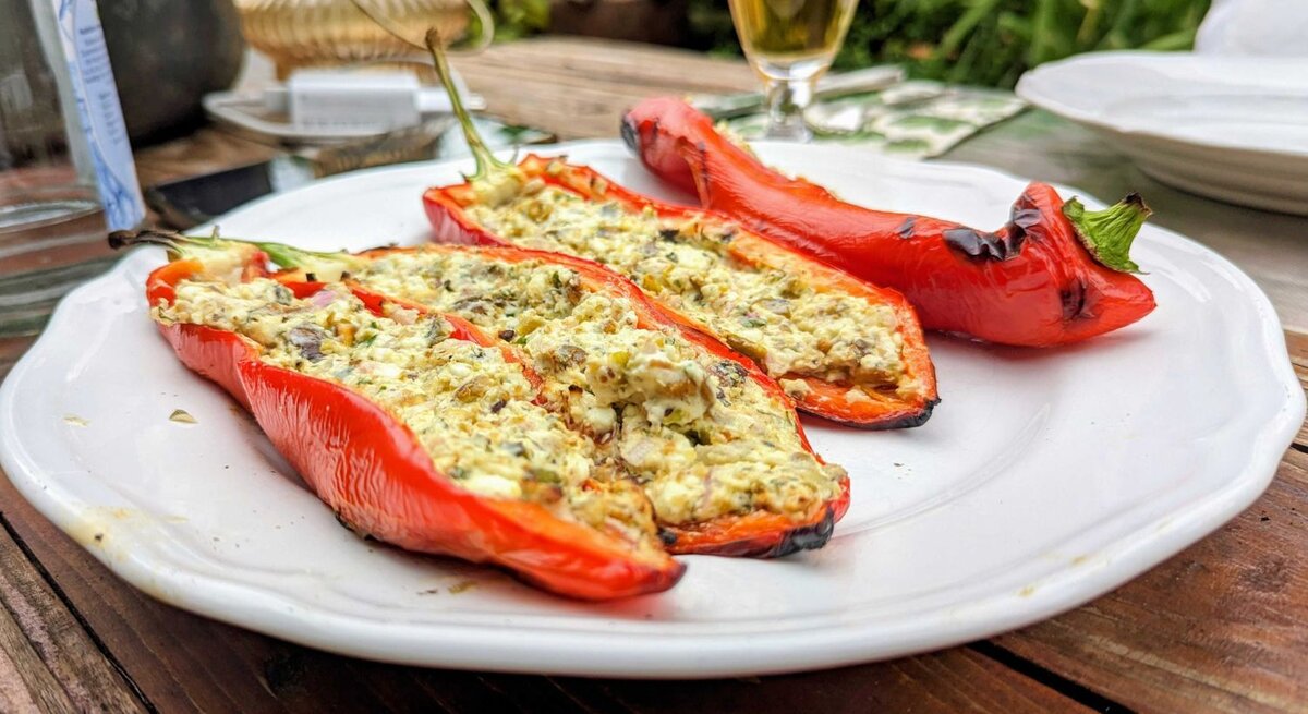 Ansicht auf mehrere gefüllte Paprikaschoten mit Feta und Pistazie.
