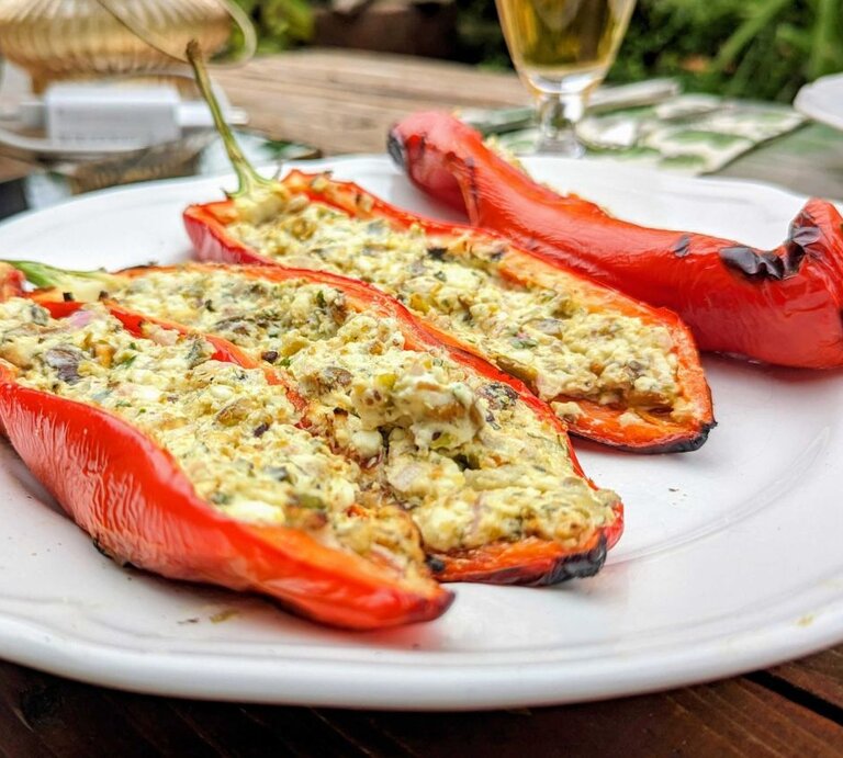 Ansicht auf mehrere gefüllte Paprikaschoten mit Feta und Pistazie.