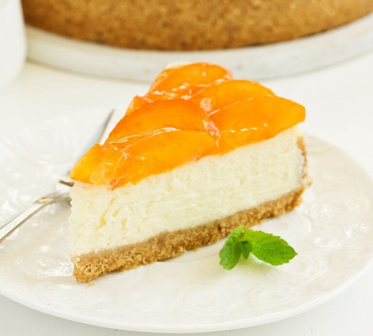 Pfirsich-Pudding-Kuchen angeschnitten auf einem Teller.  | © Shutterstock/Lesya Dolyuk