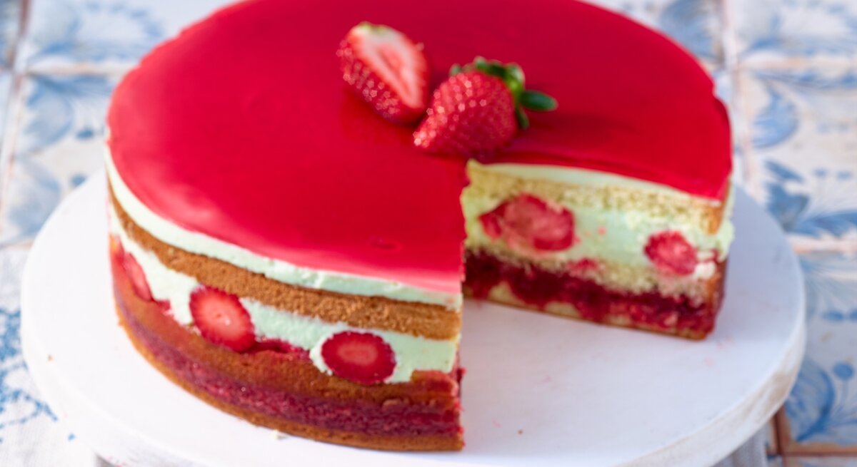 Käsesahnetorte mit Erdbeerbowlen-Kompott / angeschnitten / runder Tortenteller / Nahaufnahme / Draufsicht schräg | © Matthias Liebich