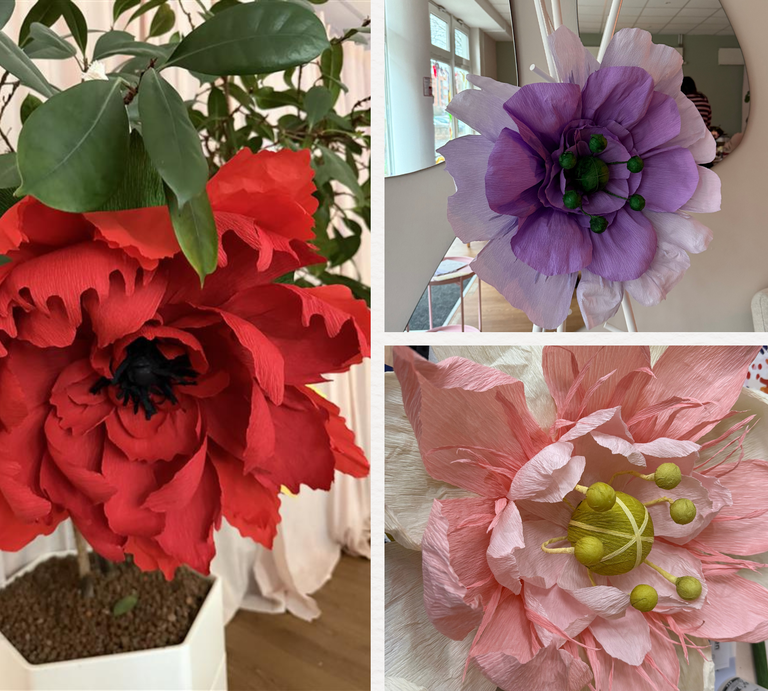 Große rote, lila und zartrosa XXL-Papierblumen mit detailreichen Blütenblättern stehen und liegen dekorativ in hellem Innenraum. | © Madeleine Liedke 