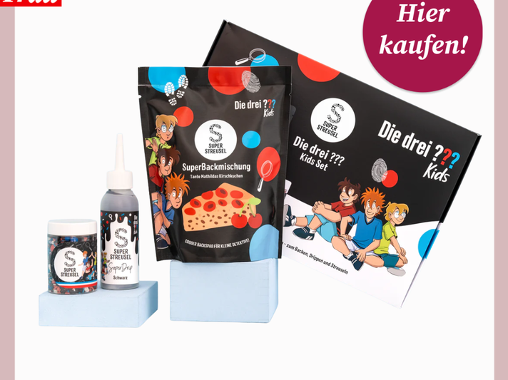 Buntes Backset mit Die drei ??? Kids-Design: Backmischung, Streusel, Lebensmittelfarbe und Box auf hellem Podest. | © Canva/Super Streusel/Collage:bildderfrau.de