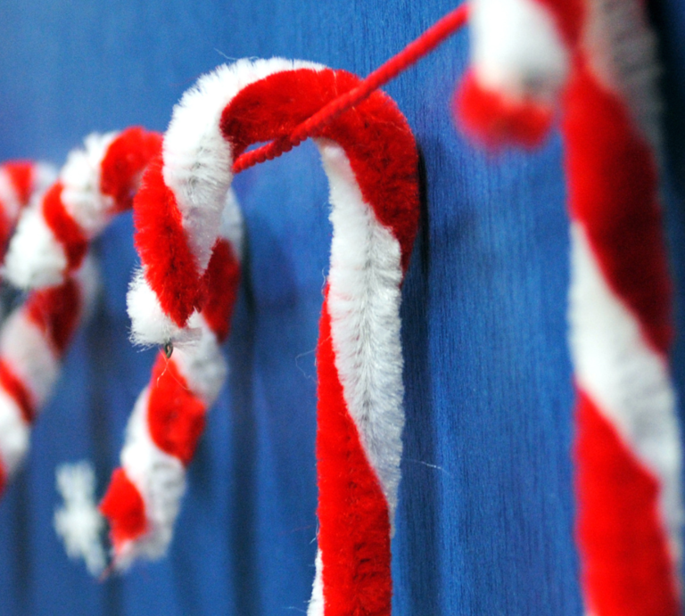 Bunte Weihnachtsdeko aus Pfeifenreinigern: Zuckerstangen, Sterne, Schneemänner, Kränze und Bastelmaterial auf Tischflächen. | © Shutterstock/VikiKrasa/Margarita Kosior/Aninka Bongers-Sutherland/Canva:bildderfrau.de