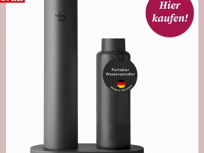 Schwarzer, minimalistischer Wassersprudler mit zylindrischem Design auf grauer Basis, daneben Flasche mit „Made in Germany“-Label. | © Canva/Amazon/Collage:bildderfrau.de