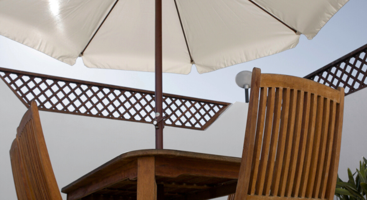 Weiße Sonnenschirme auf Balkon und Terrasse spenden Schatten über Holzmöbeln, in Nahaufnahme und Totale aus sommerlicher Perspektive.