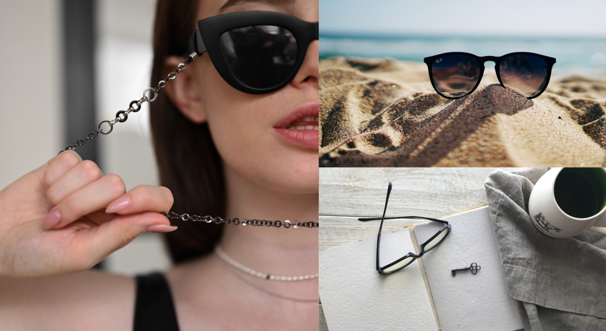 Junge Frau mit braunem Haar und schwarzer Cat-Eye-Sonnenbrille mit Kette, schwarze Sonnenbrille im Sandstrand vor Meer, schwarze Lesebrille und Schlüssel auf Notizbuch neben Tasse.