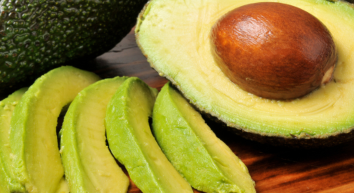 Drei Ansichten frischer Avocados: halbiert auf grünem Grund, in Scheiben geschnitten und ganz auf Holzbrett mit Löffel.