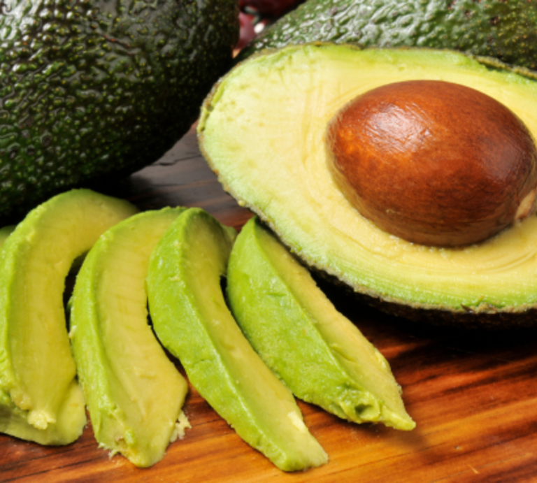 Drei Ansichten frischer Avocados: halbiert auf grünem Grund, in Scheiben geschnitten und ganz auf Holzbrett mit Löffel. | © Canva/Collage:bildderfrau.de