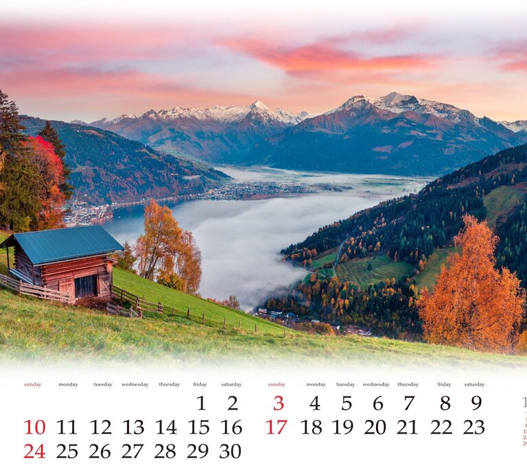 Ein Kalenderblatt, das eine kleine Holzhütte auf einer grünen Bergwiese zeigt, umgeben von Herbstbäumen, mit Blick auf einen nebelverhangenen See und schneebedeckte Berge im Morgenrot. | © Adobe Stock/Andrew Mayovskyy