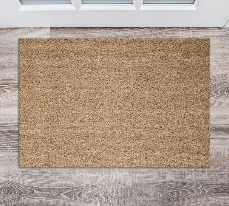 Rechteckige beige Fußmatte auf hellem Holzfußboden vor weißer Eingangstür mit Fenstern. | © Adobe Stock/maddyz