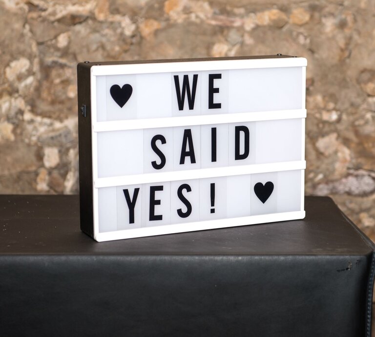 Leuchtkasten mit "We said yes!" und zwei Herzen vor einer rustikalen Steinmauer. | © Getty Images/Ingo Dörenberg