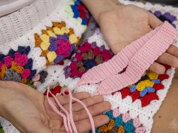 Ein gehäkeltes DIY-Haarband in rosa wird in den Händen gehalten. | © Georg Lukas