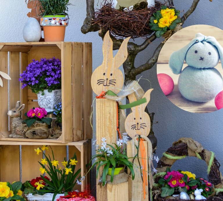 Liebevoll gestaltete Osterdekoration im Freien. Zu sehen sind Holzkisten, die als Regale dienen und mit frühlingshaften Pflanzen wie Primeln und Narzissen, sowie mit einem dekorativen Hasen gefüllt sind.  | © Adobe Stock / alho007 lizavetta [M]
