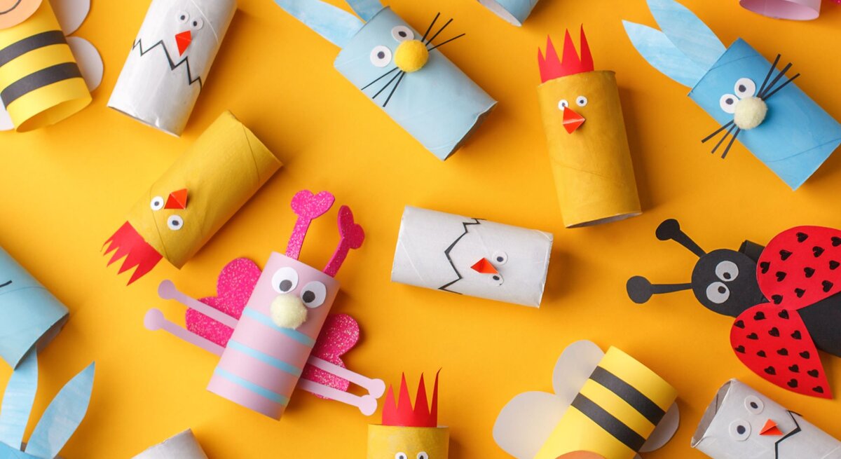  Das Bild zeigt eine bunte Sammlung von Bastelarbeiten, die aus Klopapierrollen erstellt wurden, um verschiedene Tiere und Figuren darzustellen. Diese kreativen Kreationen sind auf einem leuchtend gelben Hintergrund platziert und umfassen eine Biene mit schwarz-gelben Streifen, einen Hahn mit einer roten Krone, einen Hasen mit langen blauen Ohren, und weitere fantasievolle Charaktere wie ein Monster, eine Katze und ein Hühnchen. Jede Figur hat charakteristische Merkmale wie Augen, Schnäbel, Ohren oder Antennen, die aus Papier oder anderen Bastelmaterialien ausgeschnitten und auf die Rollen aufgeklebt wurden. Einige der Figuren haben zusätzliche Details wie Streifen, Punkte oder Herzen, die zur Individualität und zum Charme der handgefertigten Objekte beitragen. Diese Dekorationen könnten für saisonale Feste wie Ostern oder als fröhliche Zimmerdekoration für Kinder gedacht sein.
