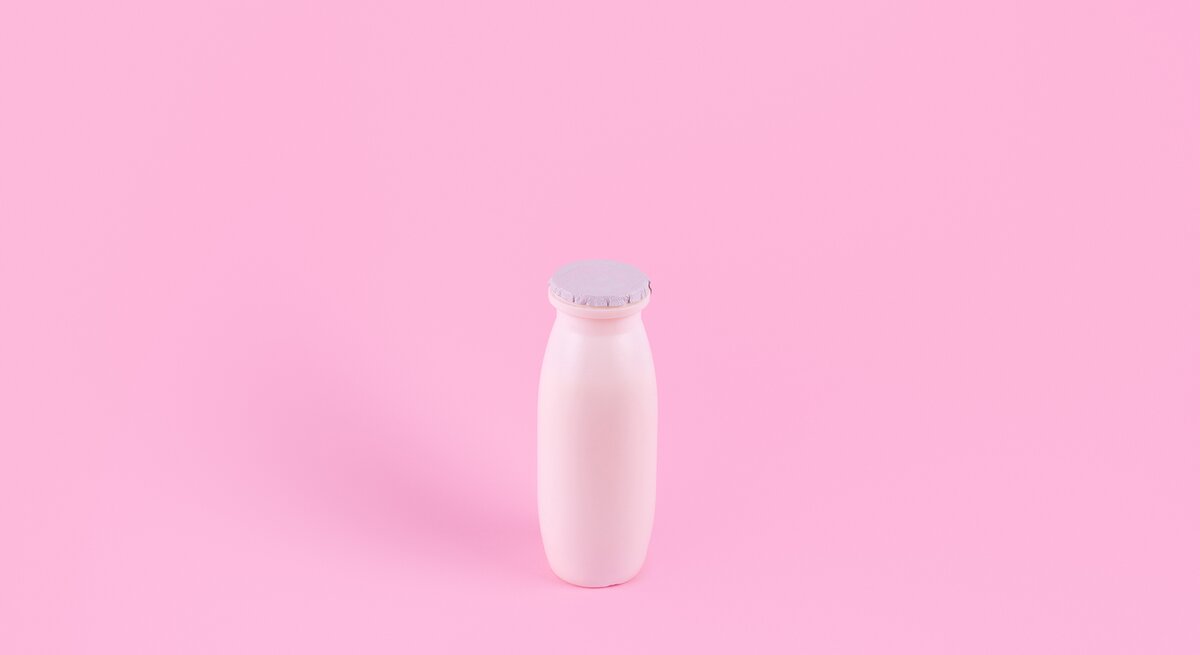 Actimel-Flasche auf rosa Hintergrund