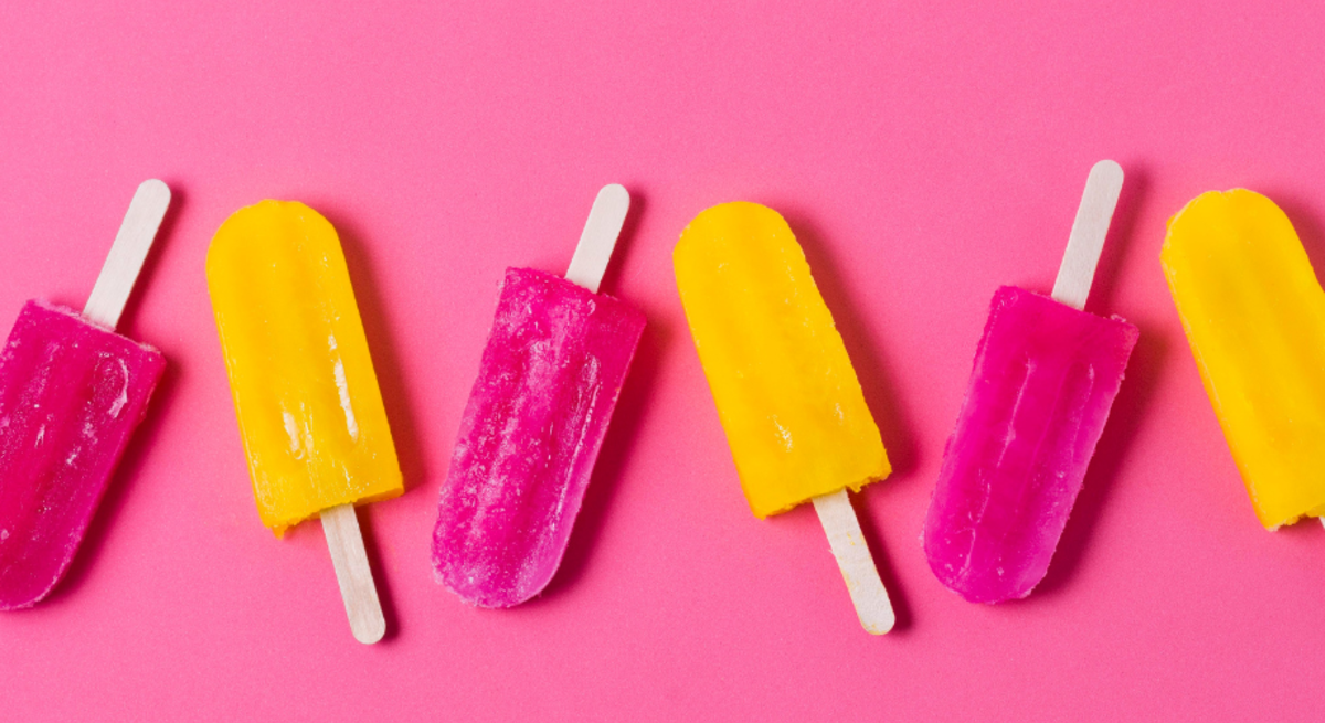 Bunte Eisstiele liegen geordnet, lose verstreut und als pink-gelbe Eis am Stiel auf knallig pink-gelb geteiltem Hintergrund.
