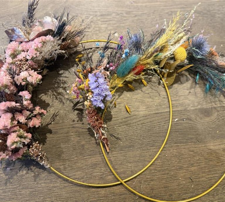 Dekokränze mit Trockenblumen auf einem Holztisch, bestehend aus bunten Blumen wie lila, rosa, gelben und grünen Naturmaterialien. | © Madeleine Liedke 