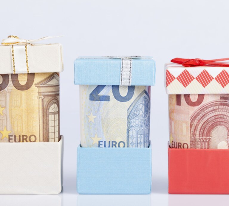Geldscheine in kleinen Geschenkboxen. | © Getty Images/ PLG
