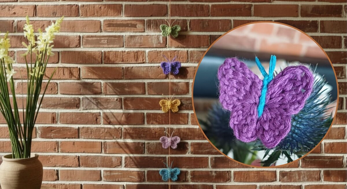 Mehrfarbige gehäkelte Schmetterlinge hängen dekorativ an einer Backsteinwand, daneben gelbe Blumen in einem Keramiktopf.