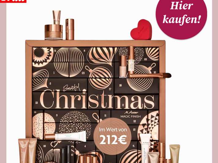 Edler Beauty-Adventskalender mit schwarzem Design und goldenen Kugeln, umgeben von Make-up-Produkten in warmen Tönen. | © asambeauty/Canva/bildderfrau.de