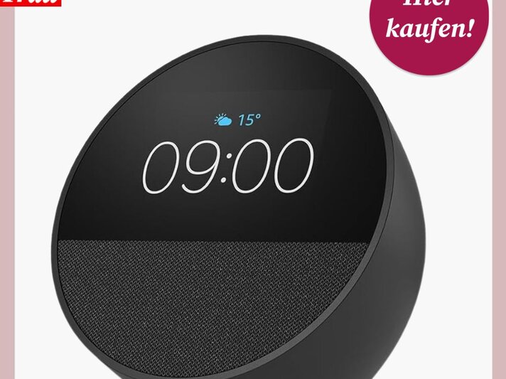 Modernes, rundes Smartgerät "Amazon Echo Spot" mit Display und Stoffüberzug zeigt Uhrzeit und Wetter, daneben ein roter Kreis mit „Hier kaufen!“. | © Amazon 
