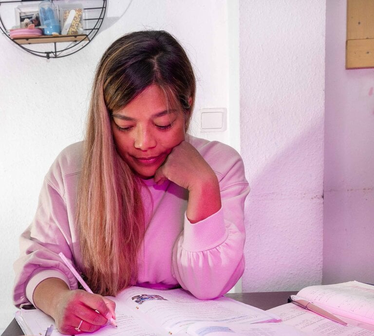 Eine Dreifach-Mama holt ihr Abi nach und sitzt lernend über den Büchern an einem Tisch. | © BILD der FRAU