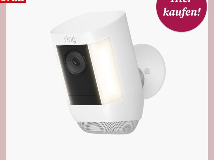 Eine weiße Überwachungskamera von Ring mit zwei seitlichen LED-Leuchten und Linse in der Mitte vor weißem Hintergrund. | © Ring
