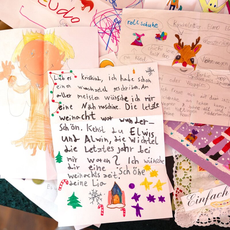 Kinderzeichnungen und Wunschlisten mit fröhlichen Farben und handgeschriebenen Botschaften, im Fokus ein Brief mit weihnachtlichen Verzierungen. | © BILD der FRAU 