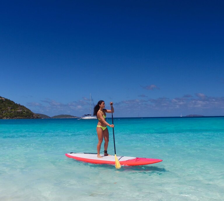 Eine Frau paddelt in der Karibik auf einem SUP, Stand Up Paddle Board. | © gettyimages/cdwheatley