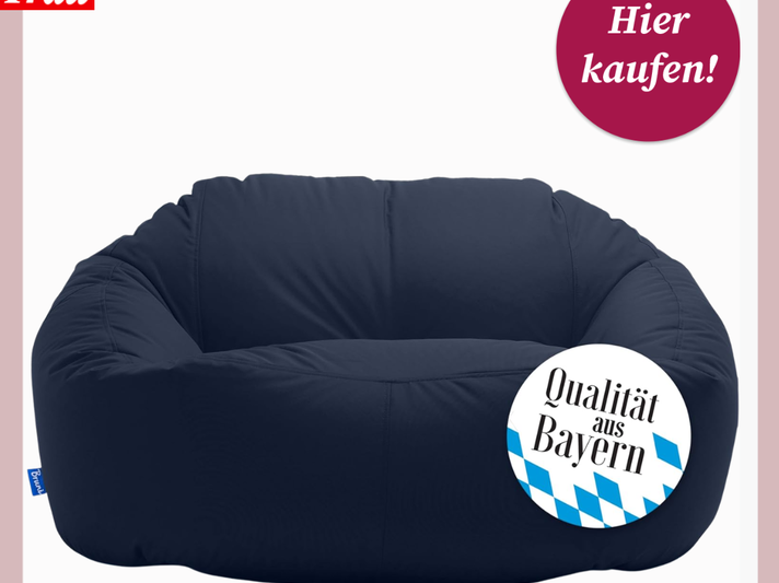 Dunkelblauer Sitzsack steht vor hellem Hintergrund, versehen mit Aufklebern „Hier kaufen!“ und „Qualität aus Bayern“. bequem! | © Amazon/Canva/Collage: bildderfrau.de