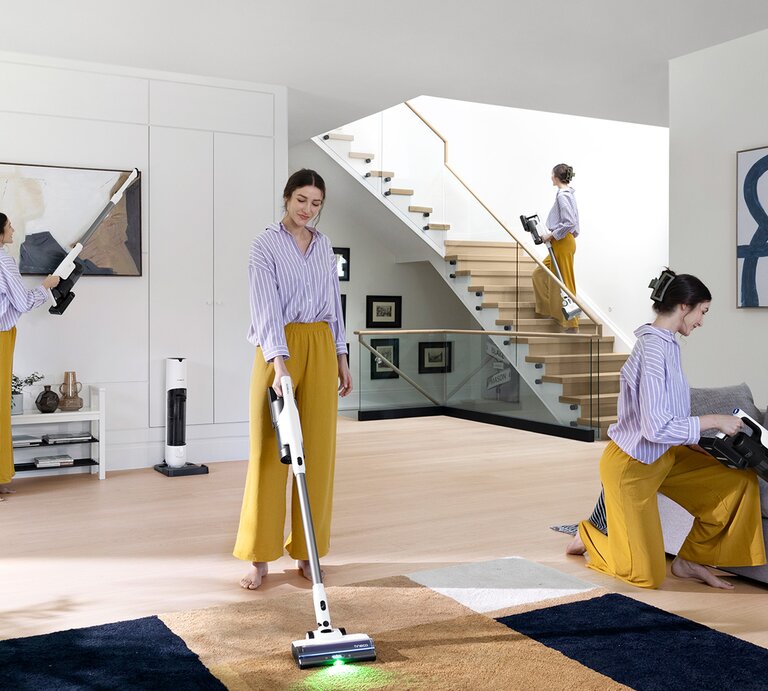 Mehrere Ansichten einer Frau mit Staubsauger reinigen ein helles, modernes Wohnzimmer, darunter Treppen, Teppich und Couch. | © Tineco