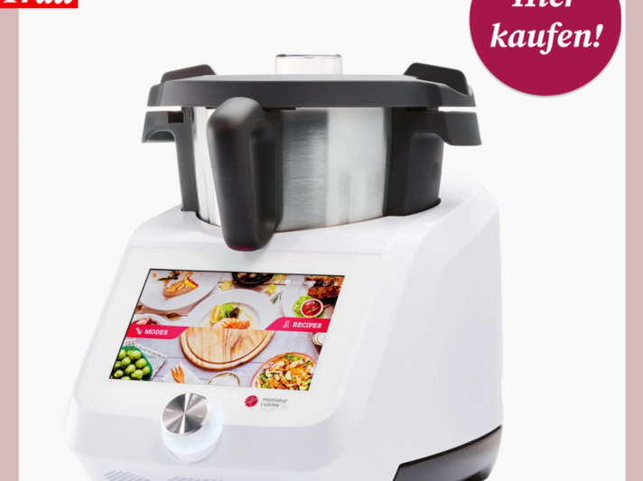  Das ist ein Bild einer multifunktionalen Küchenmaschine mit einem integrierten Farbdisplay, auf dem verschiedene Rezepte und Einstellungen angezeigt werden. Die Maschine ist überwiegend weiß mit schwarzen Akzenten und verfügt über einen Edelstahlbehälter. Oben im Bild ist das Logo von 'Bild der Frau' mit einem roten Kreis, der "Hier kaufen!" besagt, zu sehen, was darauf hinweist, dass das Bild für Werbezwecke verwendet wird, um den Verkauf dieser Küchenmaschine zu fördern. | © Lidl 